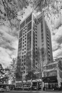 un grande edificio alto con alberi di fronte di Clarion Suites Gateway a Melbourne