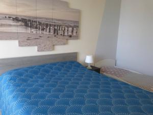 um quarto com uma cama azul e um quadro em Appartement Saint-Gilles-Croix-de-Vie, 2 pièces, 4 personnes - FR-1-224-770 em Saint-Gilles-Croix-de-Vie