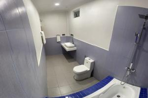 a bathroom with a toilet and a sink at Dhonveli Inn, Bandidhoo in Meedhoo