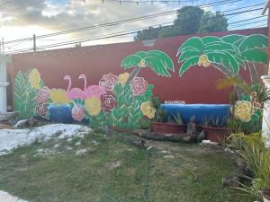 um mural numa parede com flores e palmeiras em La Casa Rosal, Pool em Campeche