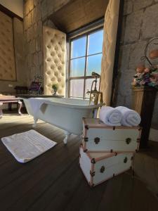 a bathroom with a bath tub and a window at Hotel Vintage "Rialto" in Quetzaltenango