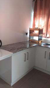 a kitchen with white cabinets and a counter top at Crystal Lake Resort in Kandy