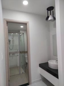 uma casa de banho com uma cabina de duche em vidro e um lavatório. em Căn Hộ Homestay Cao Cấp VinCom City Dĩ An ( Cách TPHCM 3Km) em Dĩ An