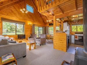 - un salon avec un canapé et une table dans l'établissement Rakau - National Park Holiday Home, à Parc national