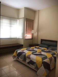 um quarto com uma cama e duas janelas em Dalila Guest Apartment at Bukit Merah by #ayahtokads em Kampong Gunong Semanggol