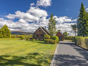 a house with a grassy yard with a pathway at Rakau - National Park Holiday Home in National Park