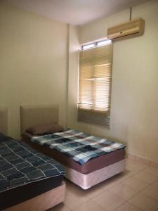 um quarto com 2 camas e uma janela em Dalila Guest Apartment at Bukit Merah by #ayahtokads em Kampong Gunong Semanggol