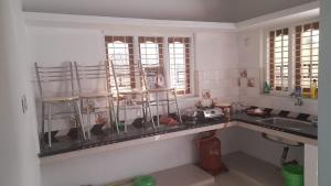 a kitchen with a counter and a sink and two windows at 7coloursholidays in Kanthalloor