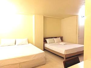 OYO 75417 Grandview Condominia في بانكوك: غرفة فندقية بسريرين وطاولة