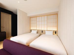 two beds sitting next to each other in a room at La'gent Hotel Kyoto Nijo in Kyoto