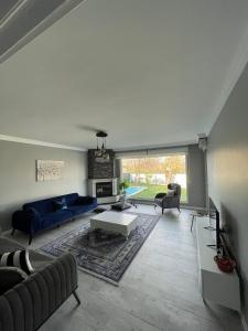 a living room with a blue couch and a table at HAN HOUSE SAPANCA in Sapanca