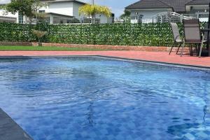 ein Swimmingpool mit blauem Wasser in einem Hof in der Unterkunft LAMAN KASEH Homestay Bukit Katil 4bedroom with Swimming Pool in Ayer Keroh