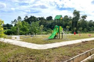 un parque infantil con un tobogán verde en LAMAN KASEH Homestay Bukit Katil Melaka, en Ayer Keroh