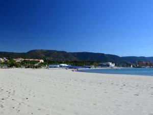una playa de arena blanca con montañas en el fondo en Maison Bormes-les-Mimosas, 2 pièces, 6 personnes - FR-1-251-273, en Bormes-les-Mimosas