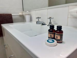 two bottles of beer sitting on a bathroom sink at Sapphire Caravan & Cabin Park in Rubyvale +35 photos