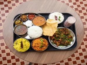 a tray filled with different types of food on a table at Aakash Rooms and Cottages, in Ooty