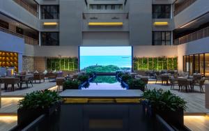 a view of a restaurant with a large screen in a building at Qianyue SSAW Boutique Hotel in Hangzhou