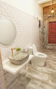 uma casa de banho com um lavatório de pedra e um WC em IPOH AGONG HOMESTAY by ONE LIFE FOUR SEASON GUESTHOUSE em Ipoh