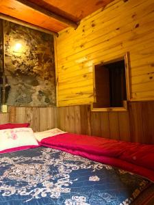 um quarto com uma cama vermelha num chalé de madeira em Trường Giang Homestay em Cao Bang