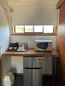 a microwave sitting on a counter in a kitchen at SHEPPARTON MOTOR INN Tudor House Motel in Shepparton