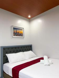 a bedroom with a bed with white sheets and a picture on the wall at ICON Venue and Suites in General Santos