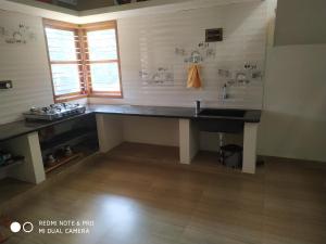 a kitchen with a sink and a counter in a room at Thotadagadde Home stay in Mudigere