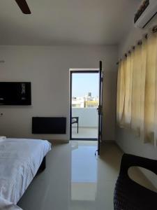 a bedroom with a bed and a sliding glass door at Alohaa Homestel in Coimbatore