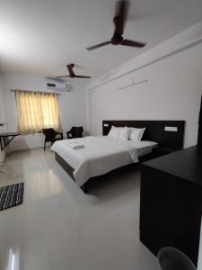 - une chambre avec un lit et un ventilateur de plafond dans l'établissement Alohaa Homestel, à Coimbatore