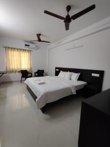 a bedroom with a bed and a ceiling fan at Alohaa Homestel in Coimbatore