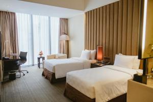 a hotel room with two beds and a desk at PO Hotel Semarang in Semarang +39 photos