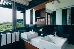 a bathroom with two sinks and two windows at Adagio Shihtiping in Fengbin
