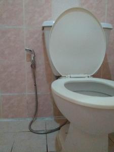 a bathroom with a toilet with a water hose at MACTAN AIRPORT HILLTOP HOTEL in Mactan