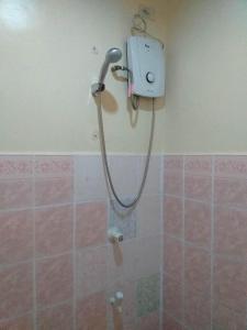 a shower in a bathroom with a hose on the wall at MACTAN AIRPORT HILLTOP HOTEL in Mactan