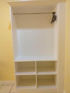 a white closet with white shelves in a room at MACTAN AIRPORT HILLTOP HOTEL in Mactan