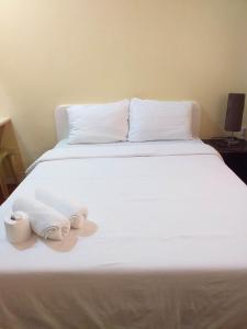 a white bed with towels on top of it at MACTAN AIRPORT HILLTOP HOTEL in Mactan