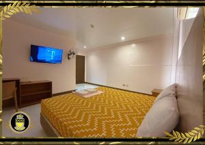 um quarto com uma cama e uma televisão na parede em White Knights Real em Dumaguete