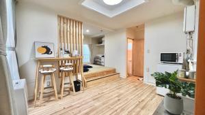 a living room with a table and a bed in it at attomi hostel in Sapporo