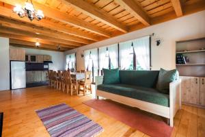 ein Wohnzimmer mit einem grünen Sofa und einem Tisch in der Unterkunft Pensiunea Sapte Flori in Gheorgheni
