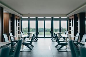 an empty cafeteria with tables and chairs and windows at Adagio Shihtiping in Fengbin +10 photos