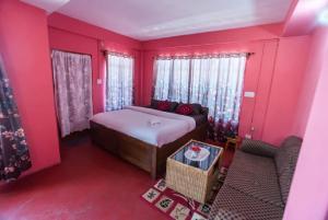 - une chambre rose avec un lit et un canapé dans l'établissement Pink Guest House, à Shillong