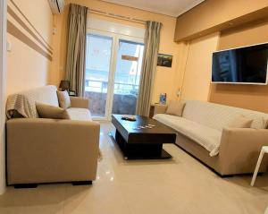 een woonkamer met 2 banken en een tv bij Apollo 1 - Luxury Apartment in Kateríni
