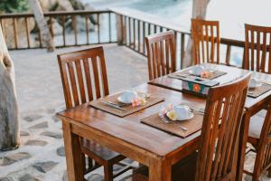 a wooden table with plates of food on it at Dini D'Nusa Lembongan in Nusa Lembongan