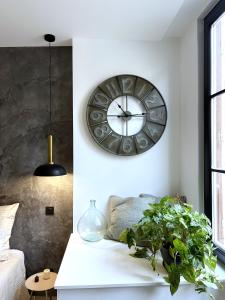 um relógio na parede acima de uma cama num quarto em Appartement - Centre Ville em Joigny