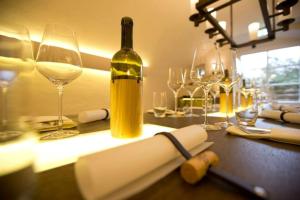 a table with a bottle of wine and wine glasses at Seminar- & Tagungshotel Große Ledder in Wermelskirchen