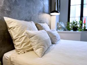 1 cama con almohadas blancas en el dormitorio en Appartement - Centre Ville, en Joigny