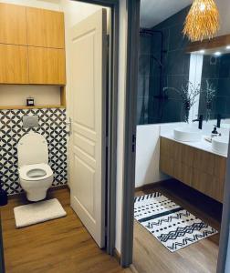 a bathroom with a toilet and a sink at SunBliss Appartement in Saint-Gilles les Bains