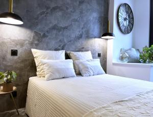 um quarto com uma cama grande e almofadas brancas em Appartement - Centre Ville em Joigny