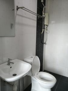 a bathroom with a white toilet and a sink at CHARISMA HOTEL in Kuantan