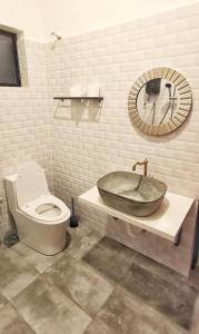 a bathroom with a sink and a toilet and a mirror at IPOH AGONG HOMESTAY by ONE LIFE FOUR SEASON GUESTHOUSE in Ipoh