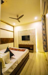 Lavanya Villa with private pool Udaipur في أودايبور: غرفة نوم مع سرير وتلفزيون على الحائط